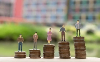 Figuras de personas colocadas sobre pilas de monedas de diferente altura, simbolizando la planificación económica o el presupuesto en una comunidad.