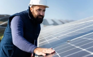 Técnico revisando paneles solares en una instalación fotovoltaica, inspeccionando su estado en una cubierta o tejado.